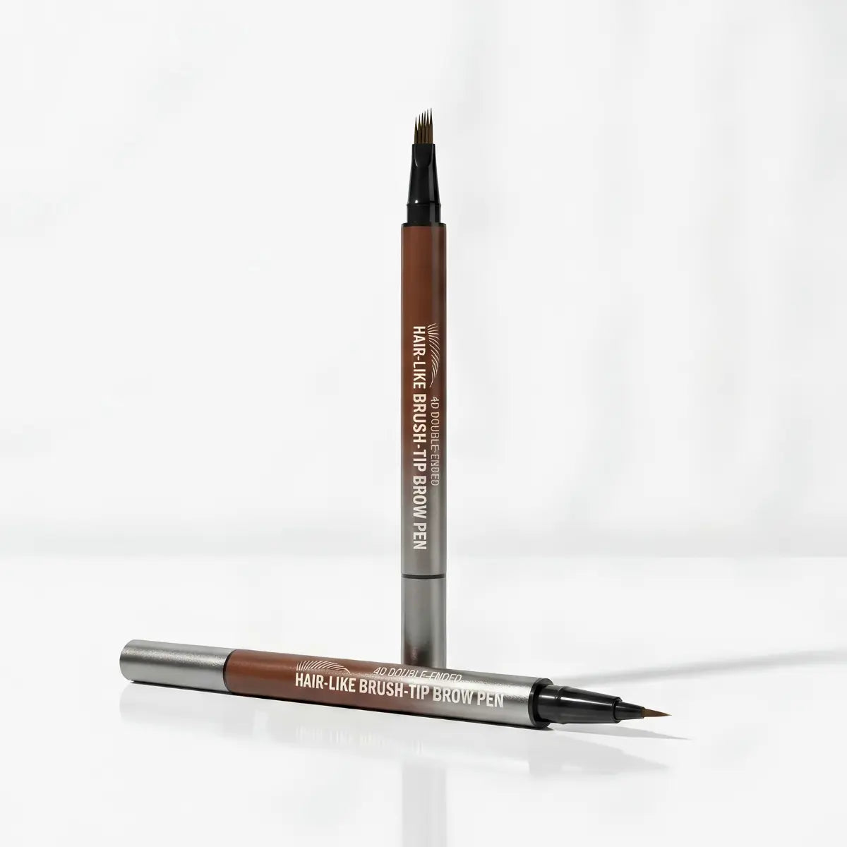 A dual-ended hair-like brush-tip brown pen shown standing upright and lying horizontally on a clean white background. The pen barrel is medium brown with silver metal ends and white printed text reading 'HAIR-LIKE BRUSH-TIP BROW PEN' and 'VIVID LANE'.